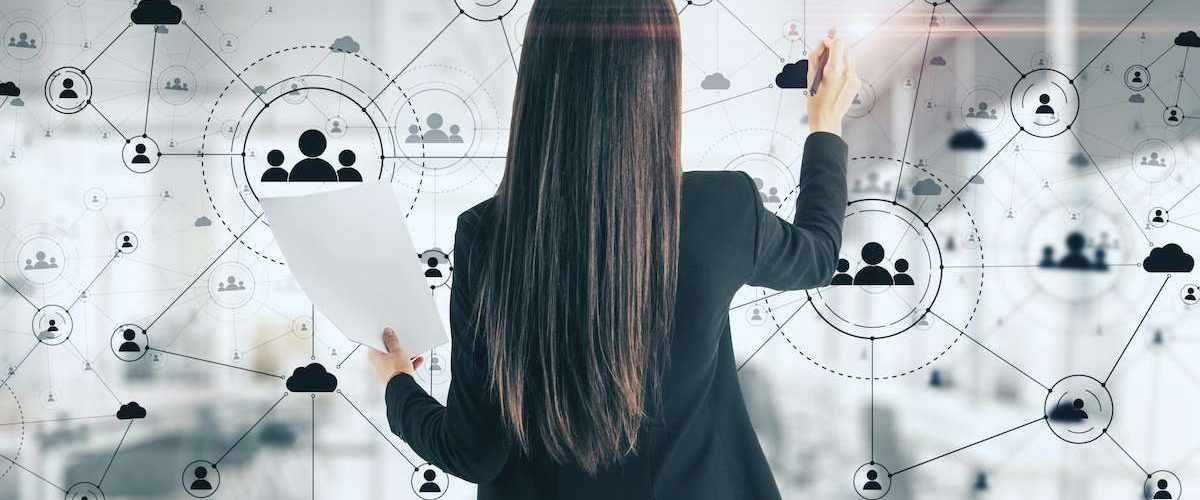 Young businesswoman drawing social network interface on virtual screen. Glowing human resource concept.
